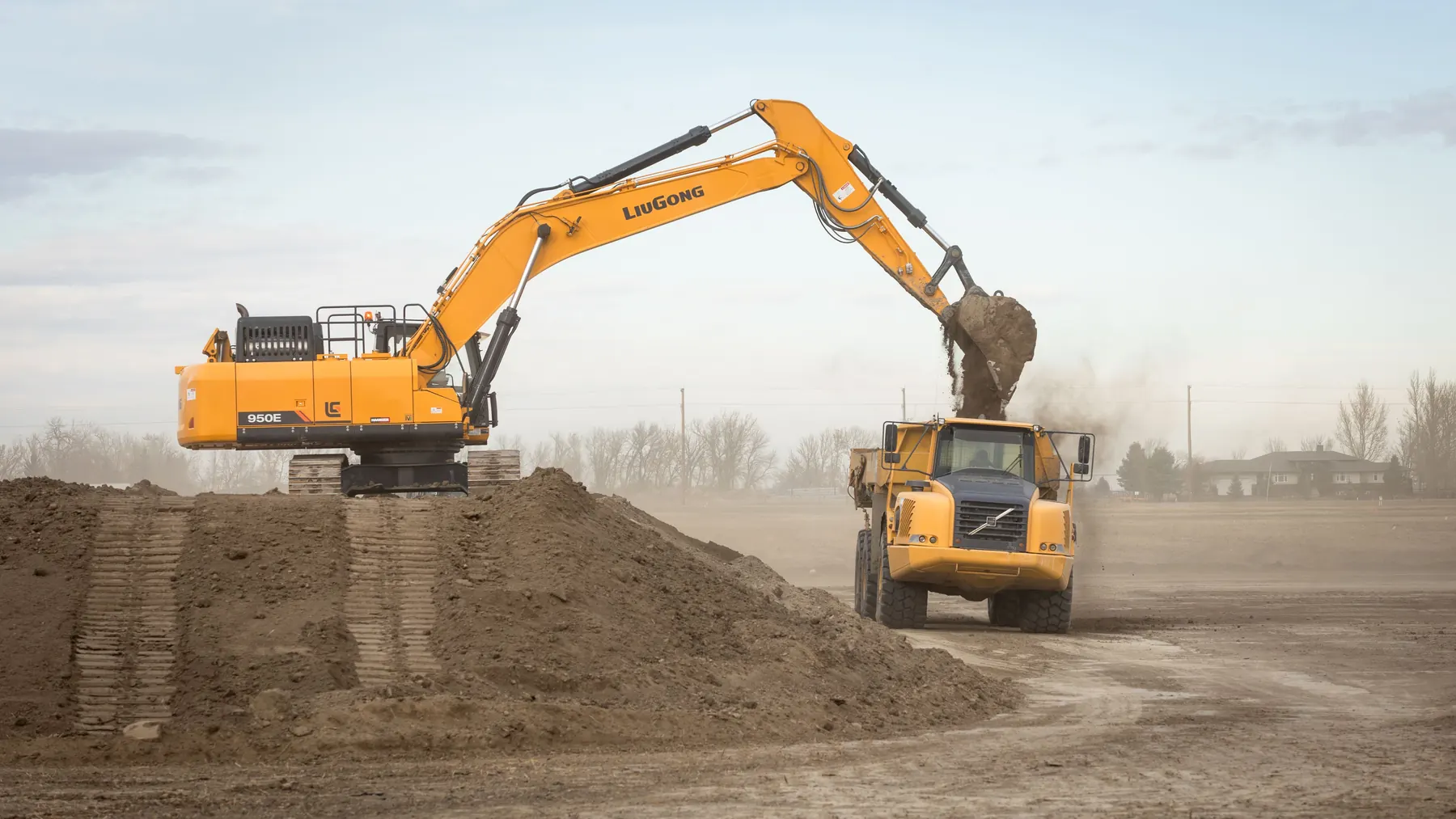 Subterrain excavator loading an articulated dump truck during earthmoving work